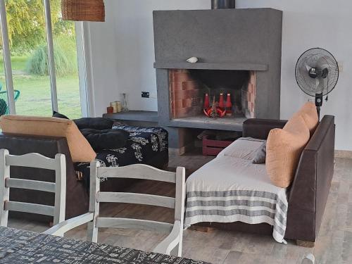 a living room with a fireplace with chairs and a couch at Sagastume in Las Toninas