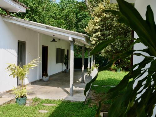 a courtyard of a house with green grass and trees at Kaela Green Villa in Ahangama