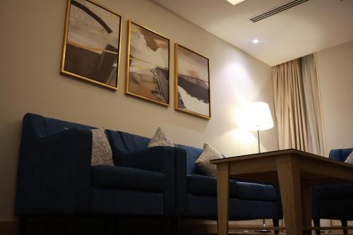 a living room with a blue couch and a table at Samtinn Hotel King Fahad in Riyadh