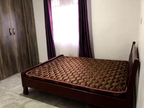a bed sitting in a room with a window at Aberdare Home Two Bedroom in Othaya