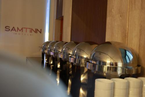 a row of white cups on a shelf in a store at Samtinn Hotel King Fahad in Riyadh