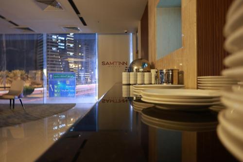 a bar in a restaurant with white dishes on the counter at Samtinn Hotel King Fahad in Riyadh