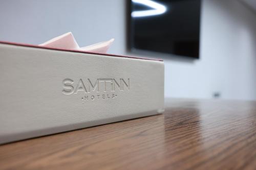 a box on a table with a tv in the background at Samtinn Hotel King Fahad in Riyadh