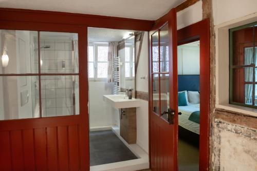 a bathroom with a red door leading to a bedroom at Haus im Zitronengässele in Lindau