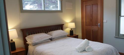 a bedroom with a bed with two pillows and a window at The Dentist on Lava - 2 bathroom. 2 bedrooms in Warrnambool