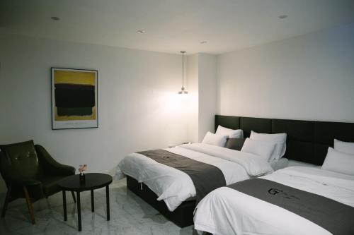 a hotel room with two beds and a chair at Gray hotel in Tongyeong
