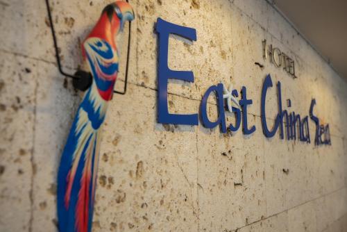 a sign on a wall with a tie on it at Hotel East China Sea in Ishigaki Island