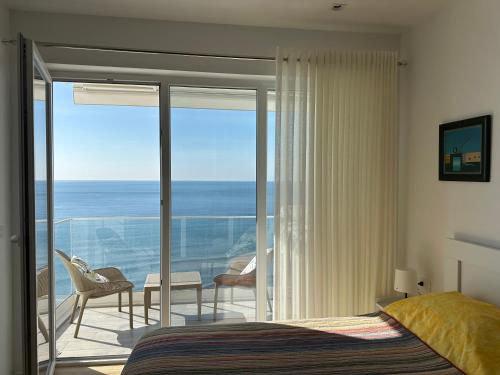 a bedroom with a bed and a balcony with the ocean at Sunset Studio Apartment in Lezhë