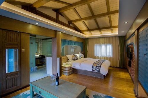 a bedroom with a bed and a table in a room at Lijiang Hearing Flower Hall Garden Inn Butterfly Language Shop in Lijiang