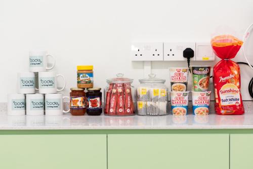 Un comptoir avec un tas de produits alimentaires. dans l'établissement Code Hostel at Kampong Glam, à Singapour