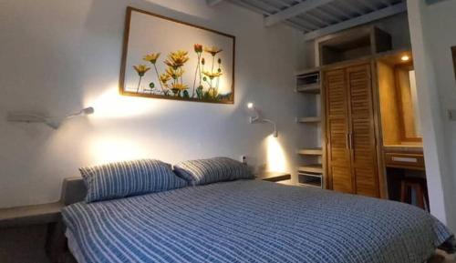 a bedroom with a bed and a picture on the wall at Altos de Guarame in Flandes