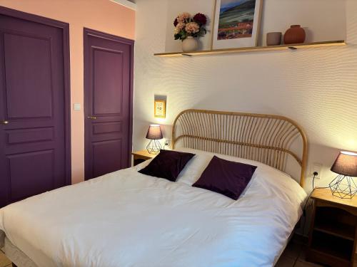 a bedroom with a white bed with two lamps at LE GOLURET Chambres & Table d'hôtes - Espace Bien Être in Couvignon