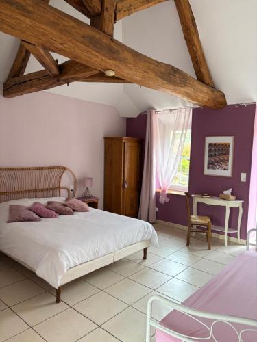 a bedroom with a large bed and a table at LE GOLURET Chambres & Table d'hôtes - Espace Bien Être in Couvignon
