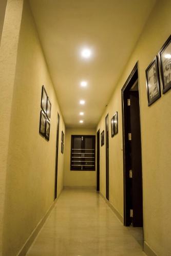 a hallway of a building with doors and pictures on the walls at The Bunkk Inn Hotel & Restaurant in Mussoorie