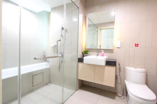 a bathroom with a shower and a toilet and a sink at Afiniti Residensi Legoland Medini in Nusajaya