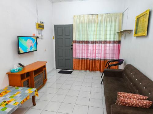 a living room with a couch and a table at Orchid Homestay Pasir Gudang in Pasir Gudang