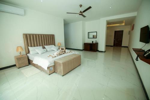a large bedroom with a bed and a television at Ruish City Hotel Kandy in Kandy