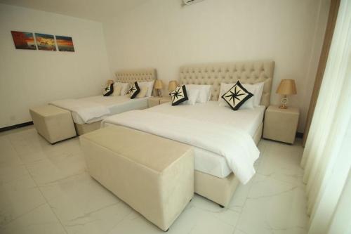 a bedroom with two beds and a couch at Ruish City Hotel Kandy in Kandy