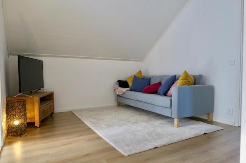 a living room with a blue couch and a tv at House near Umeå for rent in Umeå