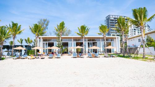a resort with chairs and umbrellas on the beach at Mirror Mirror Hotel Cafe & Restaurant in Ban Hang Ta Duk