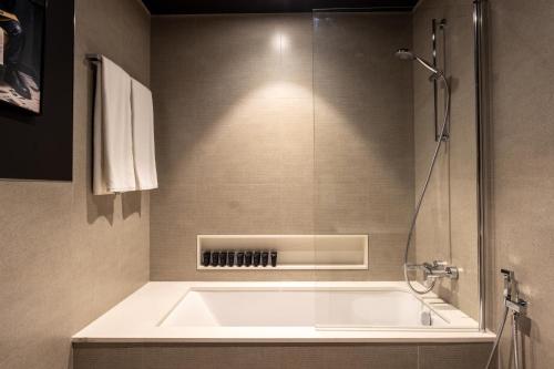 un bagno con vasca e doccia di Brand New LUXE Downtown Dubai 46th Floor a Dubai