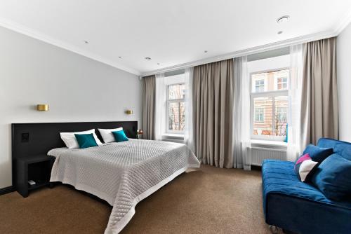 a bedroom with a bed and a blue couch at 15th Avenue in Vilnius