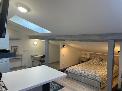 a bedroom with a bed and a table in a room at Le Terrier in Mussidan