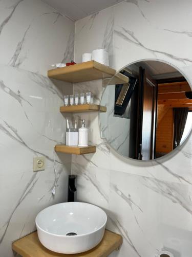a bathroom with a white sink and a mirror at Panorama Sarpi in Batumi