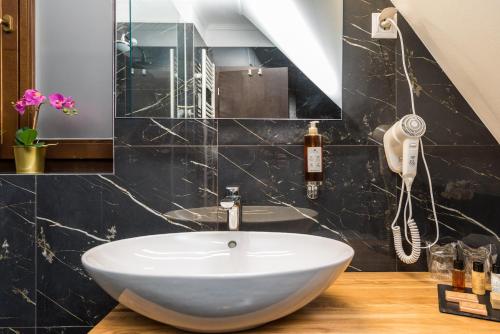 a bathroom with a white sink and a phone at Plitvice Falls Cottage in Plitvica selo