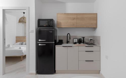 a kitchen with a black refrigerator and white cabinets at אורה דירות אירוח -נץ 9- דירות נופש איכותיות לנופש שקט ואקסלוסיבי in Eilat