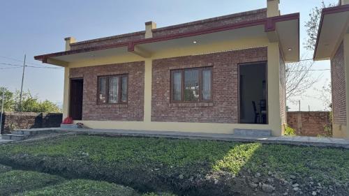 a small brick house with a front door at ROKPA Village Home Stay in Sundarijal