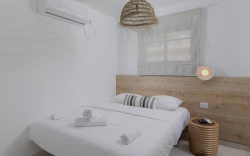 a white bedroom with two beds and a window at אורה דירות אירוח -נץ 9- דירות נופש איכותיות לנופש שקט ואקסלוסיבי in Eilat