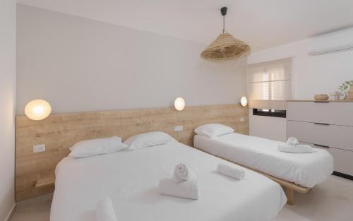two beds in a room with white walls at אורה דירות אירוח -נץ 9- דירות נופש איכותיות לנופש שקט ואקסלוסיבי in Eilat