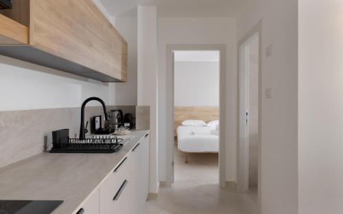 a white kitchen with a sink and a bedroom at אורה דירות אירוח -נץ 9- דירות נופש איכותיות לנופש שקט ואקסלוסיבי in Eilat