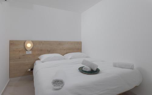 a bedroom with a white bed with a laptop on it at אורה דירות אירוח -נץ 9- דירות נופש איכותיות לנופש שקט ואקסלוסיבי in Eilat