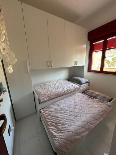 two beds in a small room with cabinets at Apartment - Solarium in San Nicola Arcella