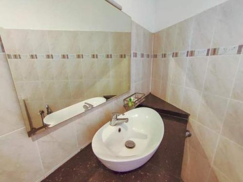 a bathroom with a white sink and a bath tub at Kandyan View Holiday Bungalow'' FREE PICKUP FROM KANDY CITY'' in Kandy