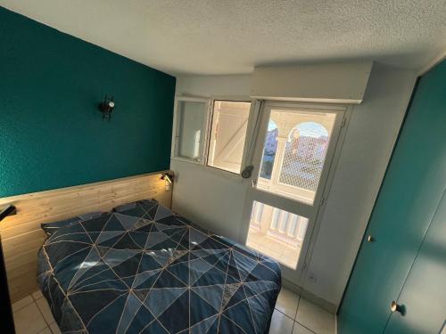 une petite chambre avec un lit et une fenêtre dans l'établissement Appartement traversant de 39 m2 4 à 6 personnes, au Barcarès