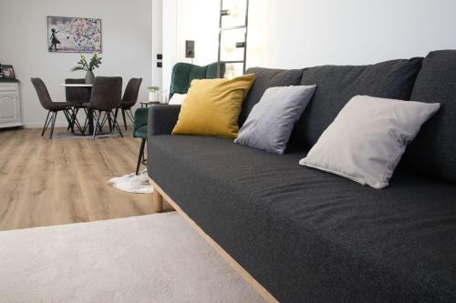 a gray couch with pillows on it in a living room at Wollfühloase Eversberg in Meschede