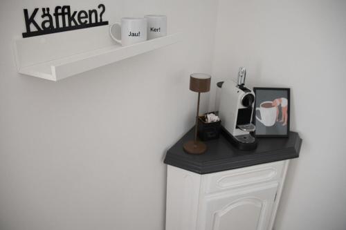 a shelf with cups and a coffee maker on a counter at Wollfühloase Eversberg in Meschede