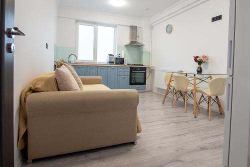 a living room with a couch and a kitchen at ByaResidence in Valea Lupului
