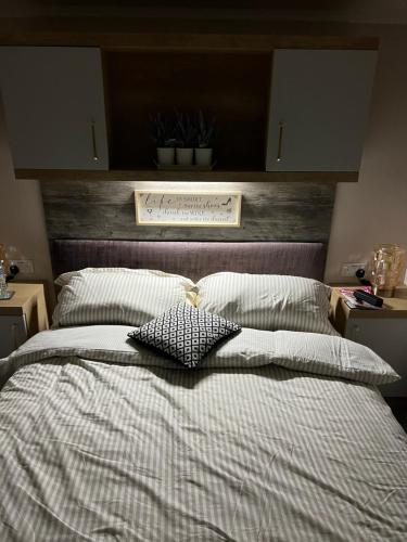 a bedroom with a large bed with a wooden headboard at Mimosa lodge in Little Clacton