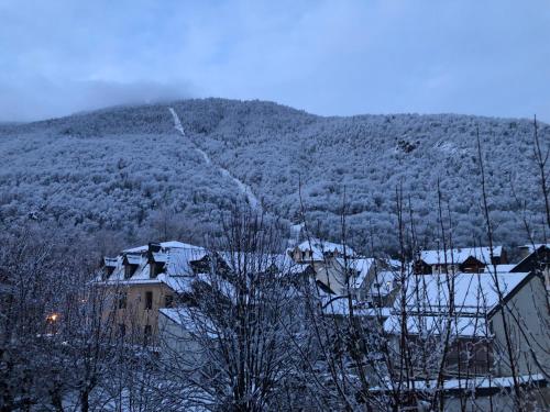 a snow covered hill with houses and a mountain at Les Jardins du Casino T2 bis- 4 personnes-Tarif cures 700 euros in Luchon