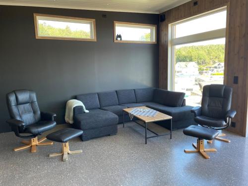 a living room with a couch and two chairs and a table at Hytte med sjøutsikt in Bamble