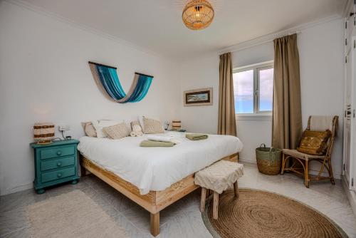 a bedroom with a large bed and a blue nightstand at Casa Hoopoe in Nazaret