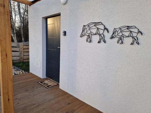 two metal animals on a wall next to a door at Chill Chaty in Tarnobrzeg