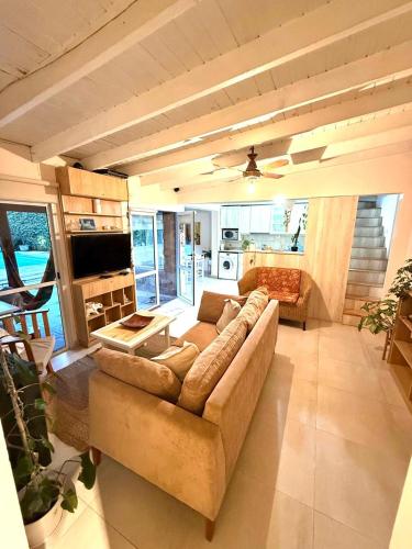 sala de estar amplia con sofá y cocina en Carpediemch, en Chascomús
