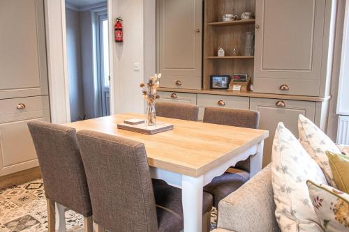 a dining room with a wooden table and chairs at Bumble Lodge New Forest in Landford