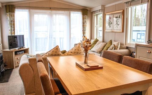 a living room with a table and a couch at Bumble Lodge New Forest in Landford
