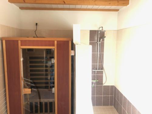 a bathroom with a shower and a glass door at Gîte Binnert Bader in Nothalten